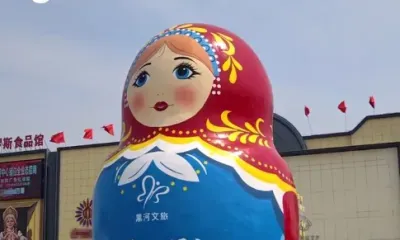 Матрешка установлена рядом с площадью, где размещен флаг КНР, заметный в Приамурье